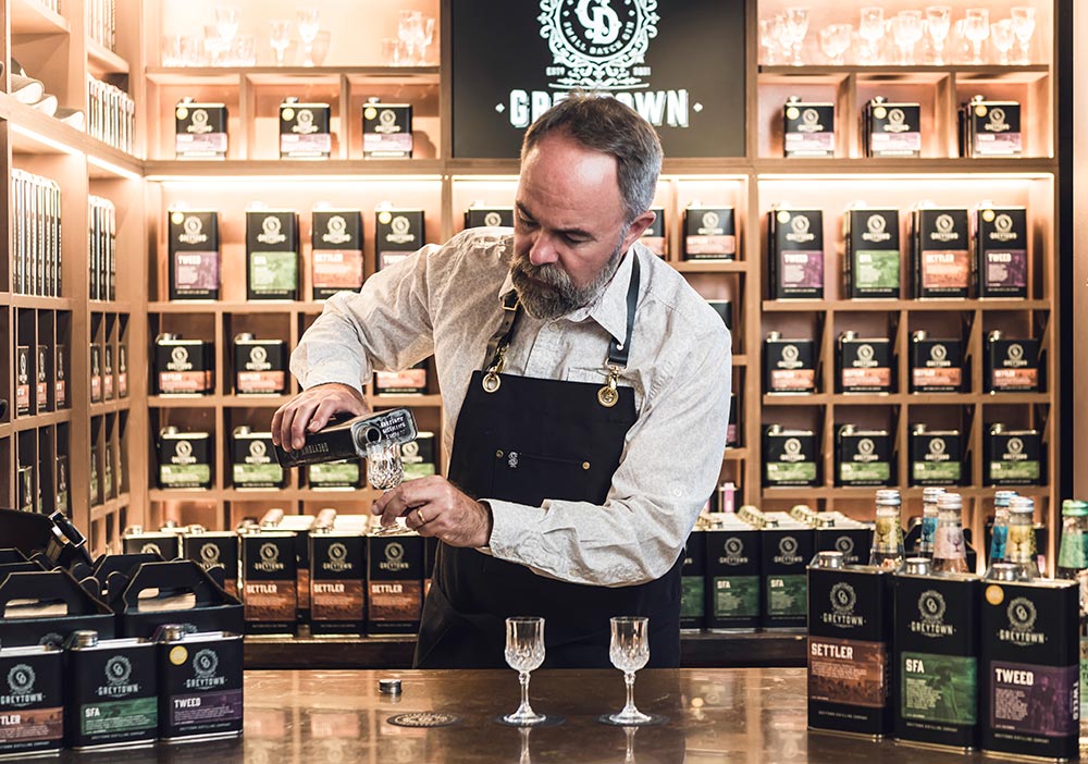 Greytown Distilling Co. Director Adam Blackwell pours a premium gin at the Tasting Shed inside the Blackwell and Sons emporium - buy these New Zealand spirits online or instore as your next gift